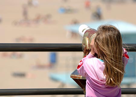 Child looking through telescope on Redondo beach