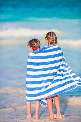 girls wrapped in a clean hotel towel on the beach